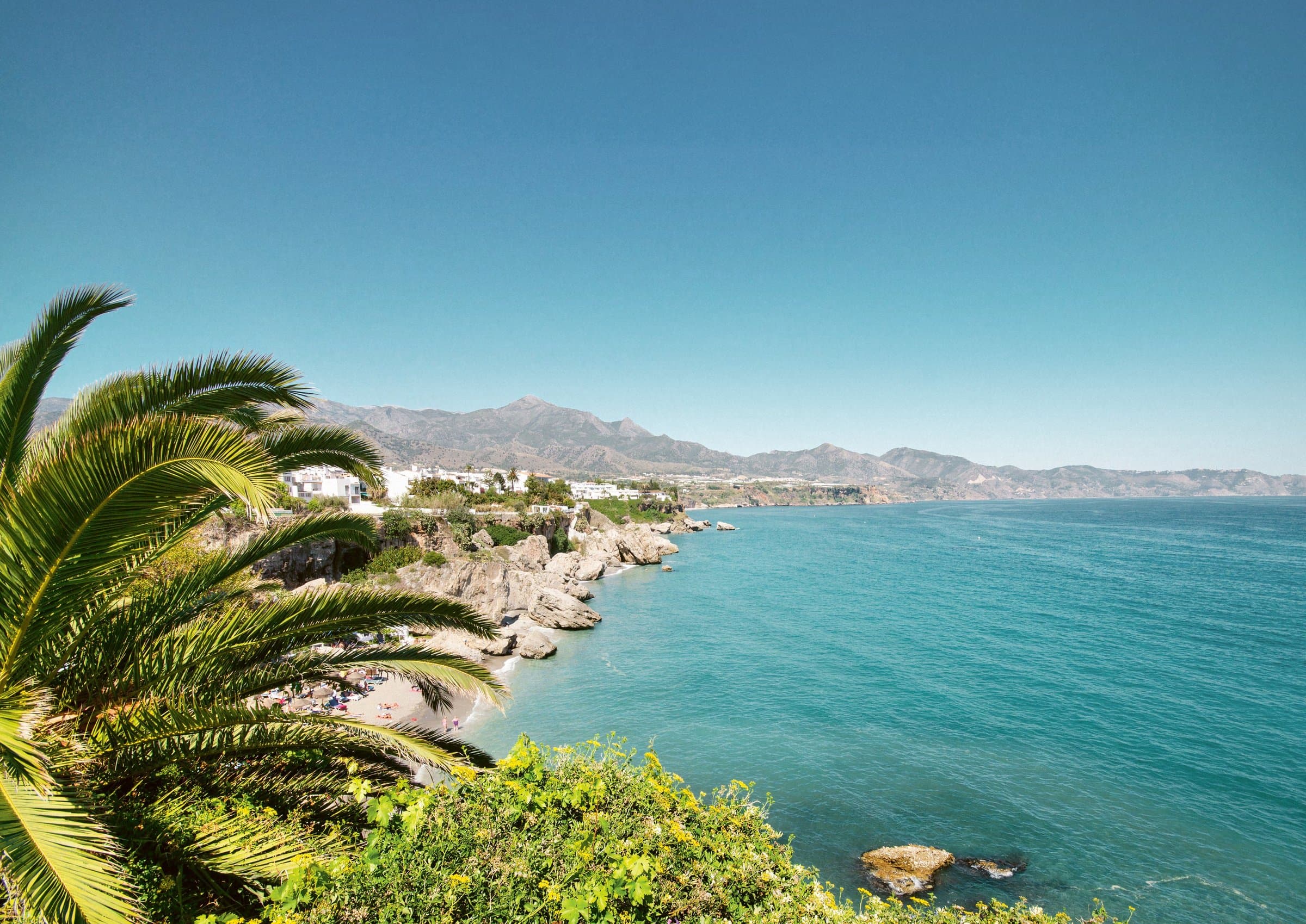 Panorama van de Andalusische kustlijn met palmen en bergen